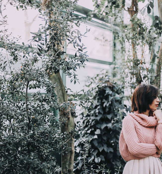 girl standing with plants in the background